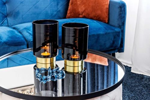 a coffee table with two candles on top of a blue couch at Best Western Hotel Savoy in Karlstad