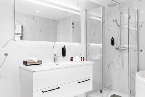 a white bathroom with a sink and a shower at Best Western Hotel Savoy in Karlstad