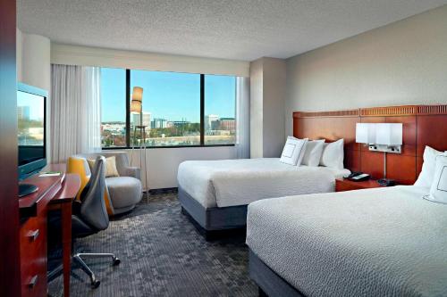 um quarto de hotel com duas camas e uma secretária em Sonesta Select Atlanta Cumberland Galleria em Atlanta