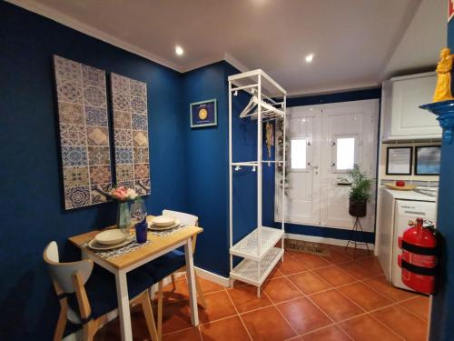 een keuken met een tafel en een blauwe muur bij Sto Antonio Guest House in Lissabon