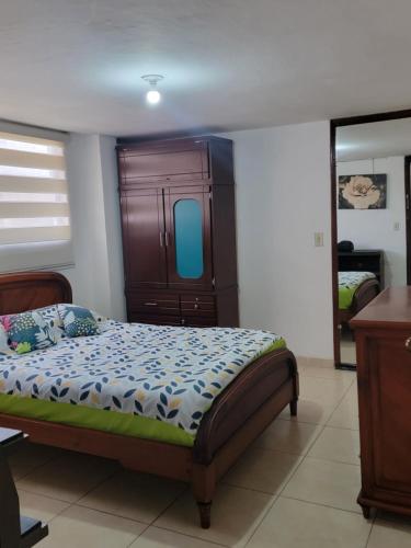 1 dormitorio con 1 cama con cabecero de madera en Habitación nueva a estrenar con baño privado completo, totalmente independiente, sector jipijapa por la plaza de toros Quito, tiene garaje, en Quito