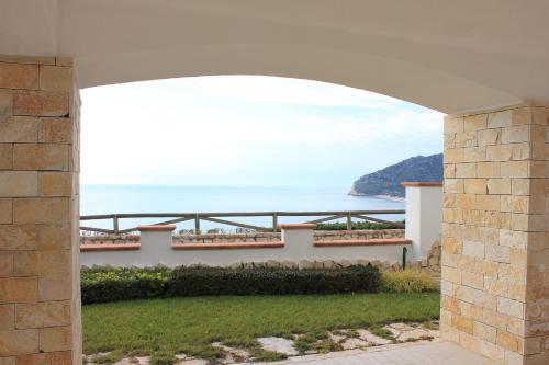 a view of the ocean through an archway of a house at Holiday Lodge al Porto in Mattinata