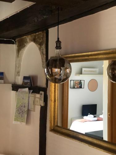 a mirror in front of a room with a bed at Apartamento Canónigo - terraza con vistas in Toledo