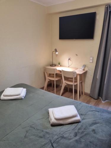 a bedroom with a desk and a bed with two towels at Isabel Guest House in Almada