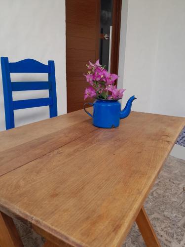 a blue vase with purple flowers sitting on a wooden table at Mykonos Carmelo in Carmelo