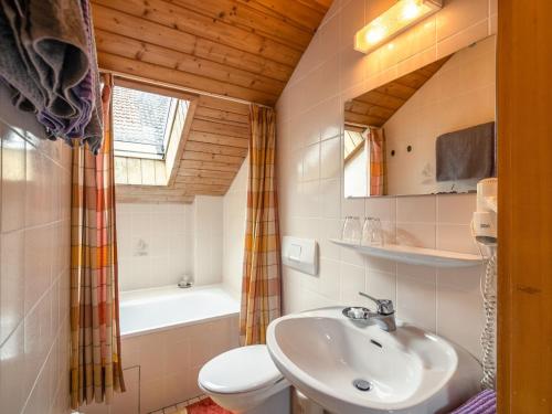 ein Badezimmer mit einem Waschbecken, einem WC und einer Badewanne in der Unterkunft Delightful Holiday Home in Unterammergau with Terrace in Unterammergau