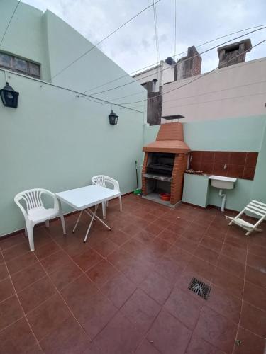 un patio con parrilla, mesa y sillas en Departamento Alicia 3 y 68 opcional cochera en La Plata