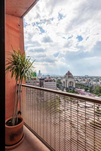 a balcony with a potted plant on a building at Reforma Apartments in Mexico City