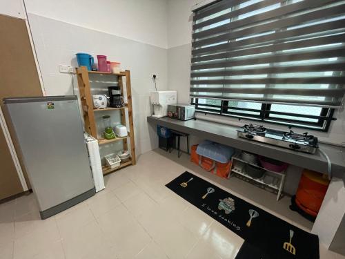 a kitchen with a counter and a window and a refrigerator at Arwaa Homestay Beachview in Bachok