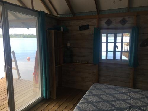 Zimmer mit Glasschiebetür und Fenster in der Unterkunft El Toucan Loco floating lodge in Tierra Oscura