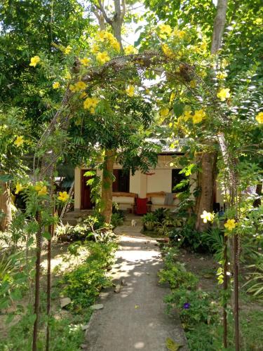 a garden with a path leading to a house at Gal's Guesthouse in Siquijor