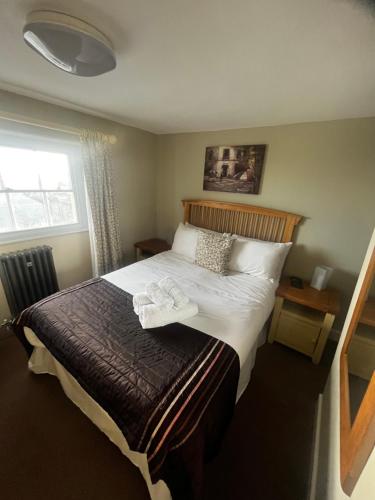 een slaapkamer met een bed met twee handdoeken erop bij The Vale Hotel in Cricklade