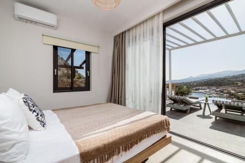 a bedroom with a bed and a balcony with a view at Villa Paganos in Volimes