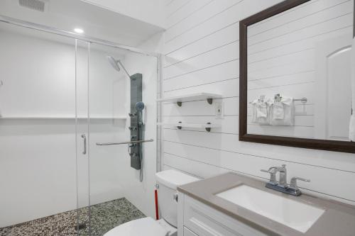 a bathroom with a toilet and a sink and a mirror at Seascape Resort & Marina in Marathon