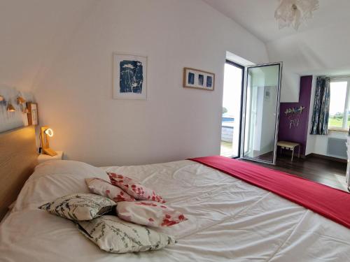 a bed with pillows on it in a bedroom at Holiday Home in Plougasnou near Sandy Beach in Plougasnou