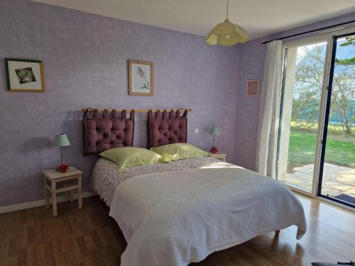 um quarto com uma cama grande e paredes roxas em Holiday home with sea view, Pordic em Pordic