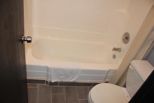 a bathroom with a white tub and a toilet at Travelodge by Wyndham Blythe in Blythe