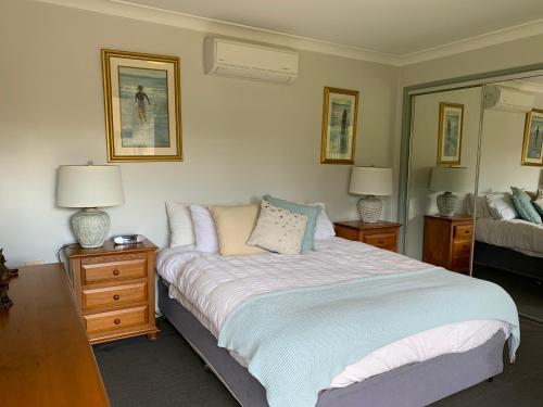 Grandmas Cottage Fairmont في Woodhill: غرفة نوم بسرير ومصباحين ومرآة