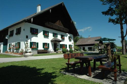 a white building with benches in front of it at Ferienhof Margarethengut in Unterach am Attersee