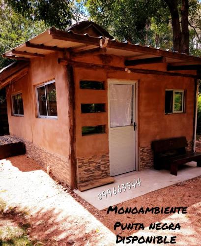 a tiny house with a porch and a door at cabañas Piriapolis punta negra 099-66-35-44 in Punta Colorada