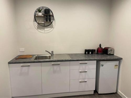 a kitchen counter with a sink and a mirror at Lakefront in Pisa in Cromwell