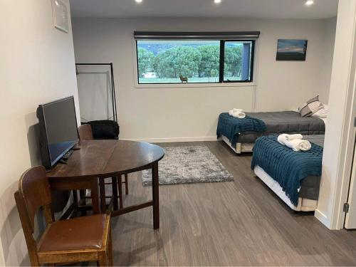 a room with a table and a bed and a desk at Lakefront in Pisa in Cromwell