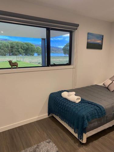 a bedroom with a bed and a large window at Lakefront in Pisa in Cromwell