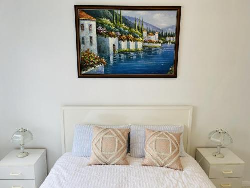 a bedroom with a bed with a painting on the wall at Spectacular Views of Sydney Harbour with Free Parking in Sydney