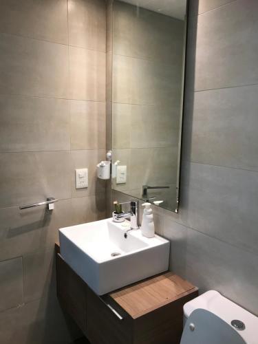 a bathroom with a sink and a mirror and a toilet at Gala Vista in Punta del Este