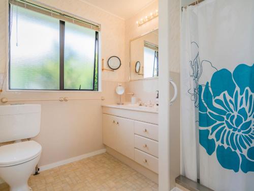 a bathroom with a toilet and a sink and a shower at Treasure on Chestnut - Tairua Holiday Home in Tairua