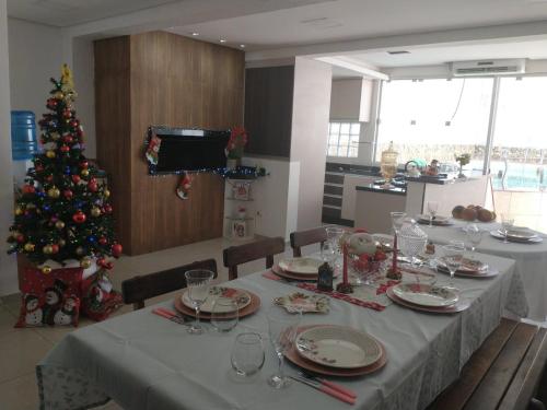 un comedor con una mesa con un árbol de Navidad en Casa Centro de Foz do Iguaçu com piscina e churrasqueira, en Foz do Iguaçu