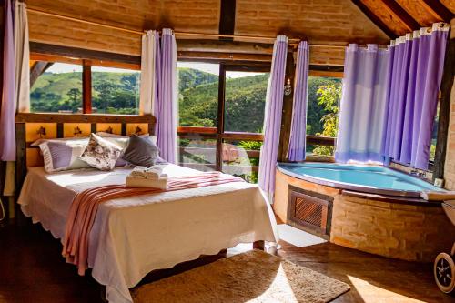 um quarto com uma cama e uma banheira num quarto em Pousada Chalé Sol Nascente em Santo Antônio do Pinhal