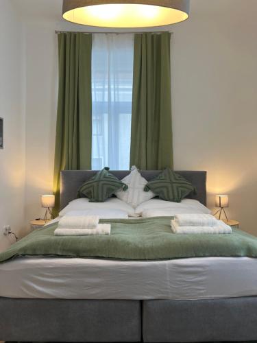 a bedroom with a large bed with green curtains at Prater Tree big 3 room apartment near Innere Stadt in Vienna