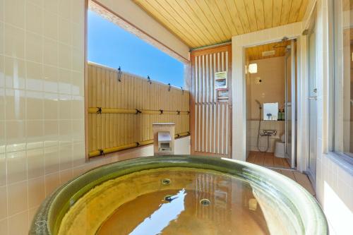 La salle de bains est pourvue d'une grande baignoire et d'un lavabo. dans l'établissement KAMENOI HOTEL Kitsuregawa, à Sakura