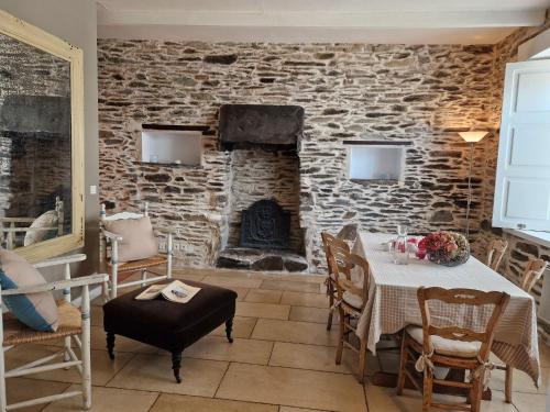 une salle à manger avec une table et une cheminée dans l'établissement House in Locquirec near Sandy Beaches, à Locquirec