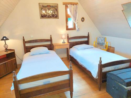 1 dormitorio con 2 camas, mesa y ventana en Breton granite stone house with fantastic sea views, en Saint-Pol-de-Léon