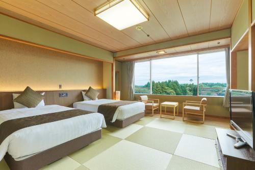 Cette chambre comprend deux lits et une grande fenêtre. dans l'établissement KAMENOI HOTEL Kitsuregawa, à Sakura