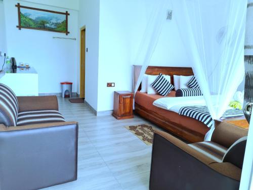 a bedroom with a bed and two chairs in a room at Ever Green Mount in Ella