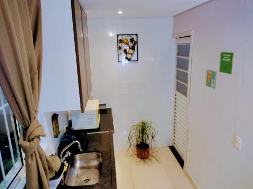 a hallway with a room with white walls and a window at Pousada Ideal Guarujá - Estúdios Mobiliados, Ar-Condicionado e Cozinha in Guarujá