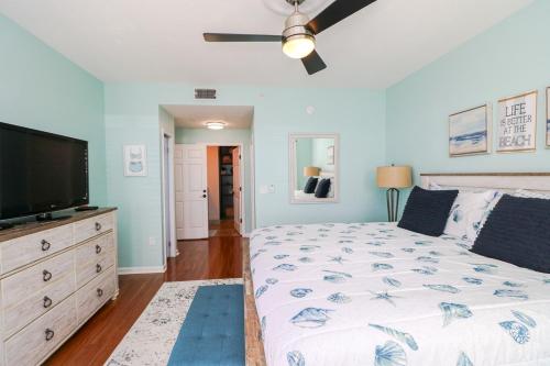 a bedroom with a bed and a flat screen tv at Seaside at Anastasia A304 in St. Augustine