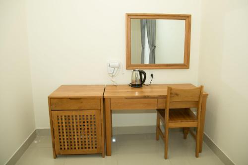 a wooden desk with a mirror on a wall at BĂNG BOUTIQUE HOTEL in Thu Dau Mot