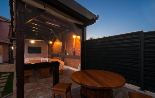 eine Terrasse mit einem Tisch und Stühlen sowie einem TV in der Unterkunft Stunning Home In Hrvace With Heated Swimming Pool in Hrvace