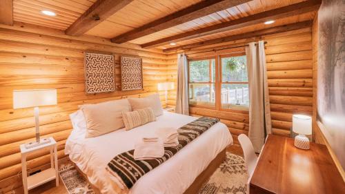 1 dormitorio con 1 cama en una cabaña de madera en Amenity Packed A-frame Cabin With Two Bedrooms And Loft, en Gainesville