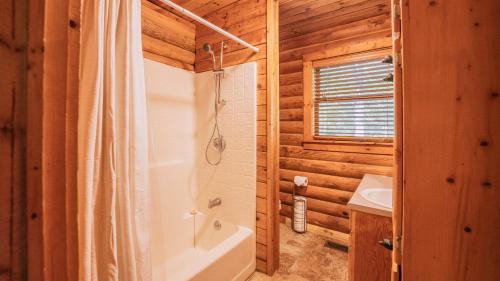 y baño con ducha, bañera y lavamanos. en Amenity Packed A-frame Cabin With Two Bedrooms And Loft, en Gainesville