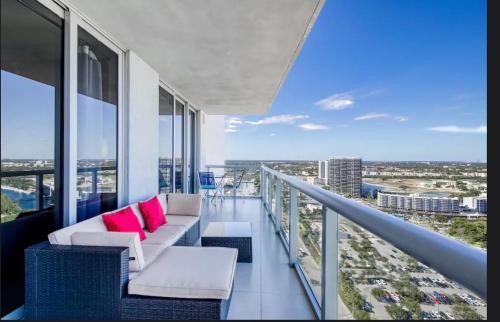 a balcony with couches and pink pillows on a building at Stunning Penthouse Suite Waterfront 2BD 2BA in Hallandale Beach