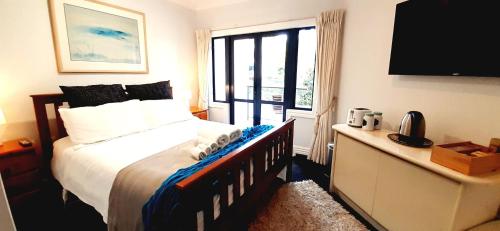 1 dormitorio con cama y ventana grande en Takapuna Accommodation, en Auckland