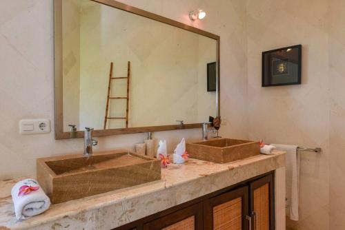 uma casa de banho com 2 lavatórios e um espelho grande em Villa Lumba-Lumba1 em Umeanyar