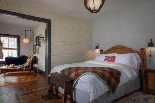 een slaapkamer met een bed, een stoel en een tafel bij Howland House in Mount Tremper