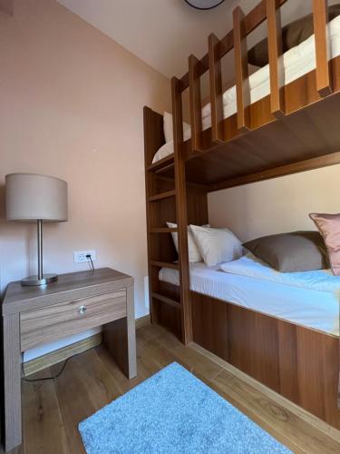 a bedroom with two bunk beds and a table with a lamp at Apartman Vučko B328 in Jahorina