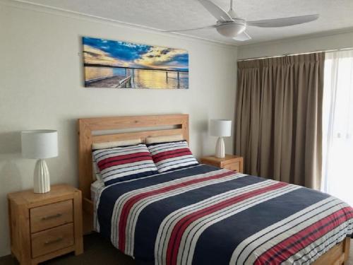 um quarto com uma cama com dois candeeiros e uma pintura na parede em Surfside Court - Hosted by Burleigh Letting em Gold Coast